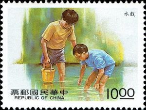 Boys playing in water with bucket