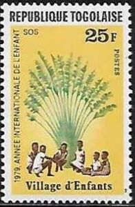 Children sitting under African fan palm
