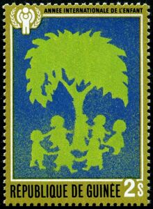 Children dancing around tree