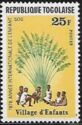 Children sitting under African fan palm