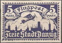 Airplane flying over the silhouette of the skyline of Danzig